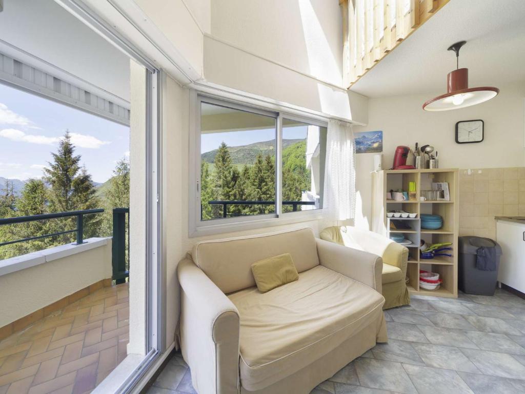 a living room with a couch and a large window at Appartement avec mezzanine pour 4, vue sur Gourette - FR-1-400-49 in Gourette