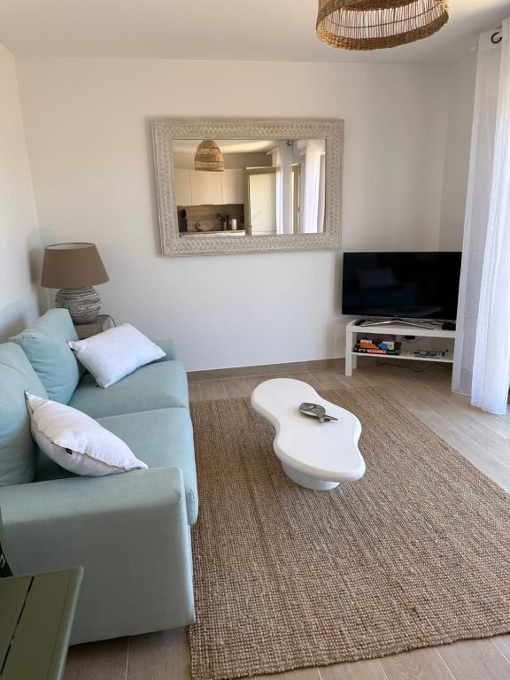 a living room with a blue couch and a table at Les palmiers Maxime in Sainte-Maxime