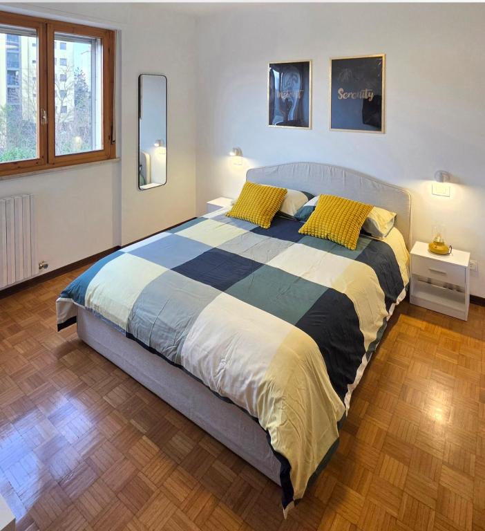 a bedroom with a large bed with yellow pillows at La Casa di Draf Appartamento Humanitas IEO Forum in Rozzano
