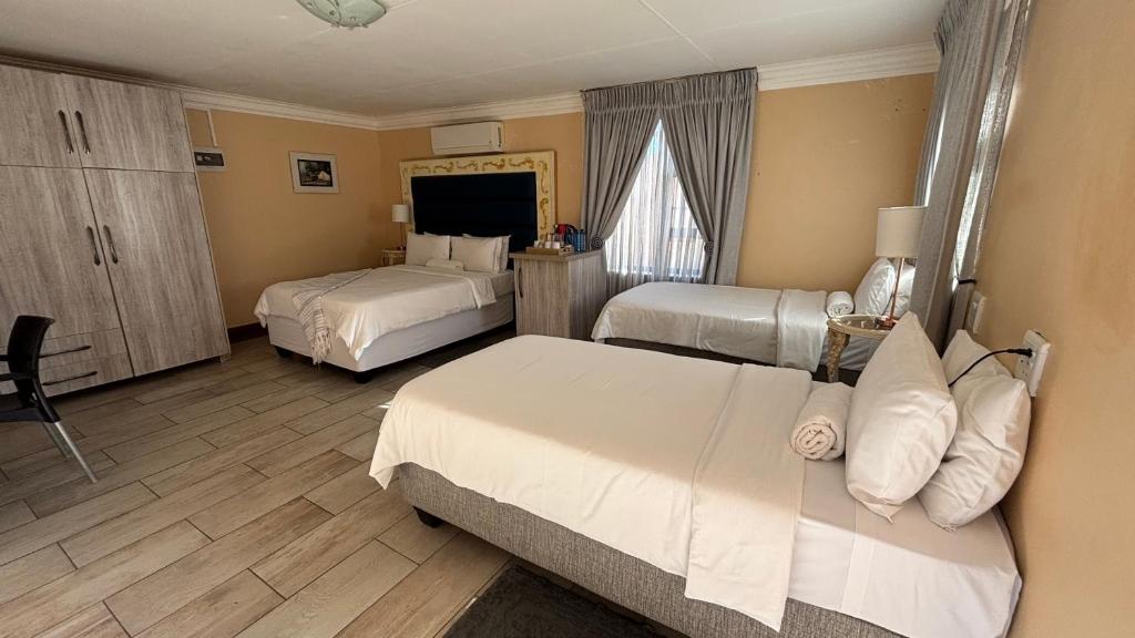 a hotel room with two beds and a window at Guesthouse 116 on McLean in Welkom