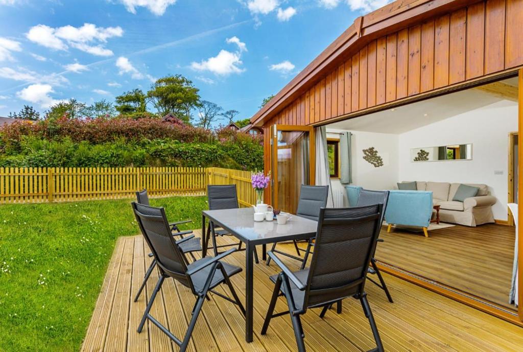 a patio with a table and chairs on a deck at L54 - Sunny Corner in Truro