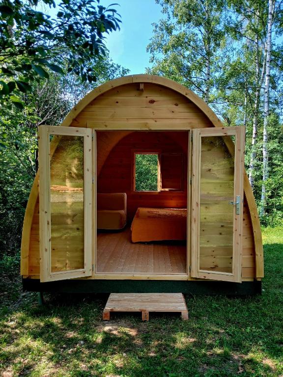 a wooden cabin with a bed and a window at Il glomere - campeggio di Rorà in Rorá