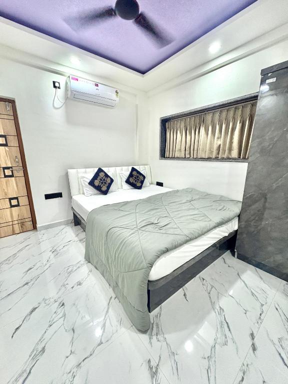 a bedroom with a bed with a marble floor at Hotel Siyaram Inn in Trimbak