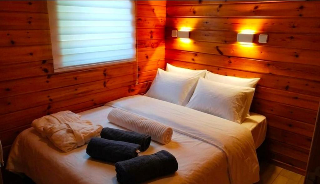 a bedroom with a large bed with wooden walls at הבקתות במושבה in Rosh Pinna