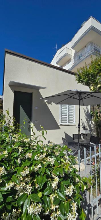a building with an umbrella and a table and chairs at La Casina di Luca in Rimini