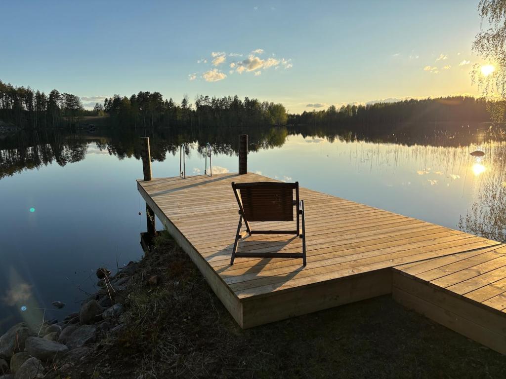 ein Stuhl steht auf einem Steg an einem See in der Unterkunft StrandRo 2 in Hirvensalmi