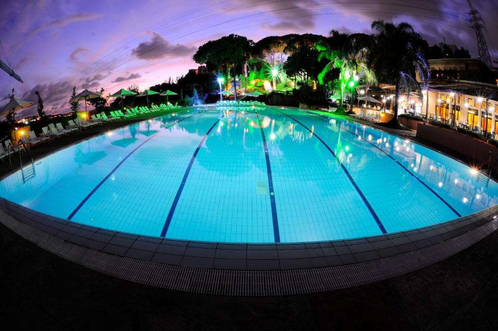 a large pool with blue water at night at Country Lodge Hotel & Resort Beirut in Beirut