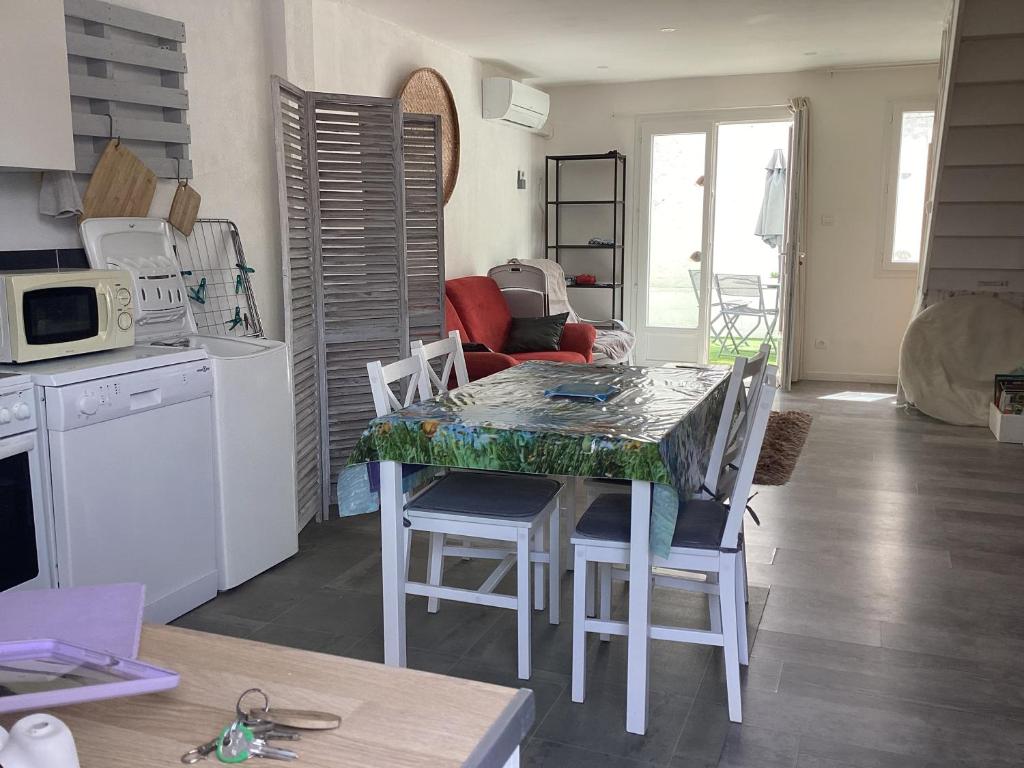 a kitchen with a table and some chairs and a kitchen with a tableablish at Celimène in Canet-en-Roussillon