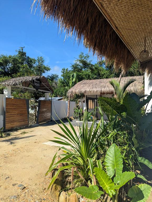 a building with a straw roof and a palm tree at Maison PAYAPA PORT BARTON in San Vicente
