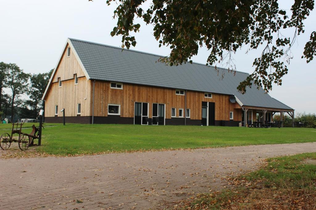 a large wooden barn sitting on top of a field at B&B Hof 't Sprakel in Haaksbergen