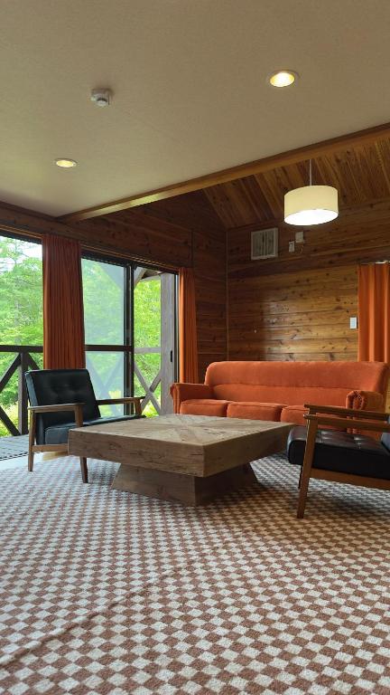 a living room with a couch and a coffee table at Maruta なんもく村 in Minamimaki