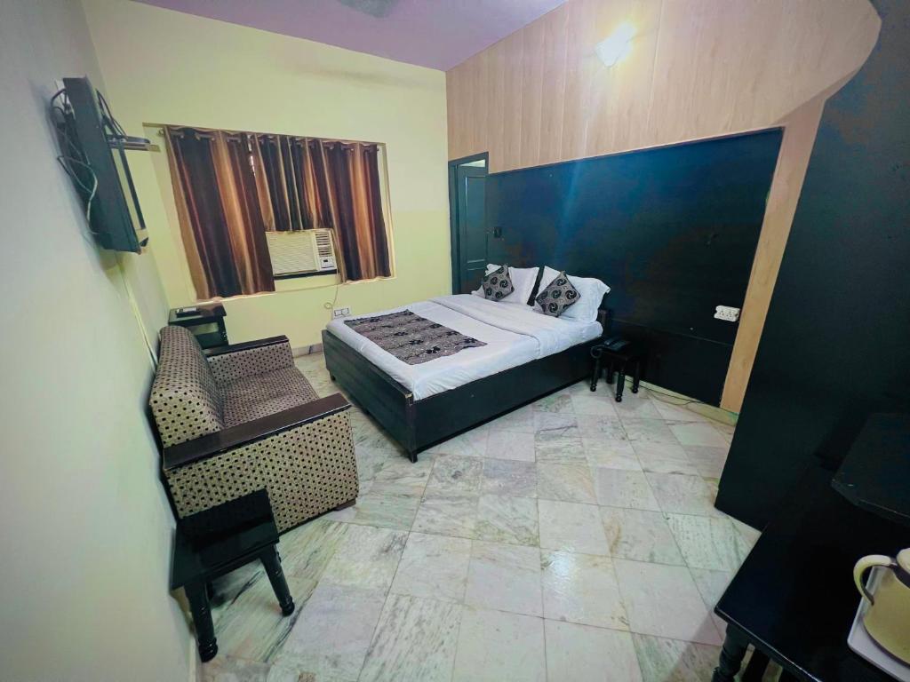 a bedroom with a bed and a chair in a room at Gaurav Boarding House in Mathura