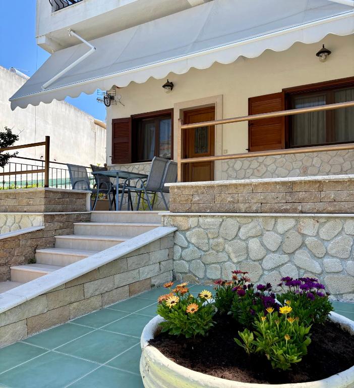 a house with a patio with stairs and flowers at Thalassa in Siviri
