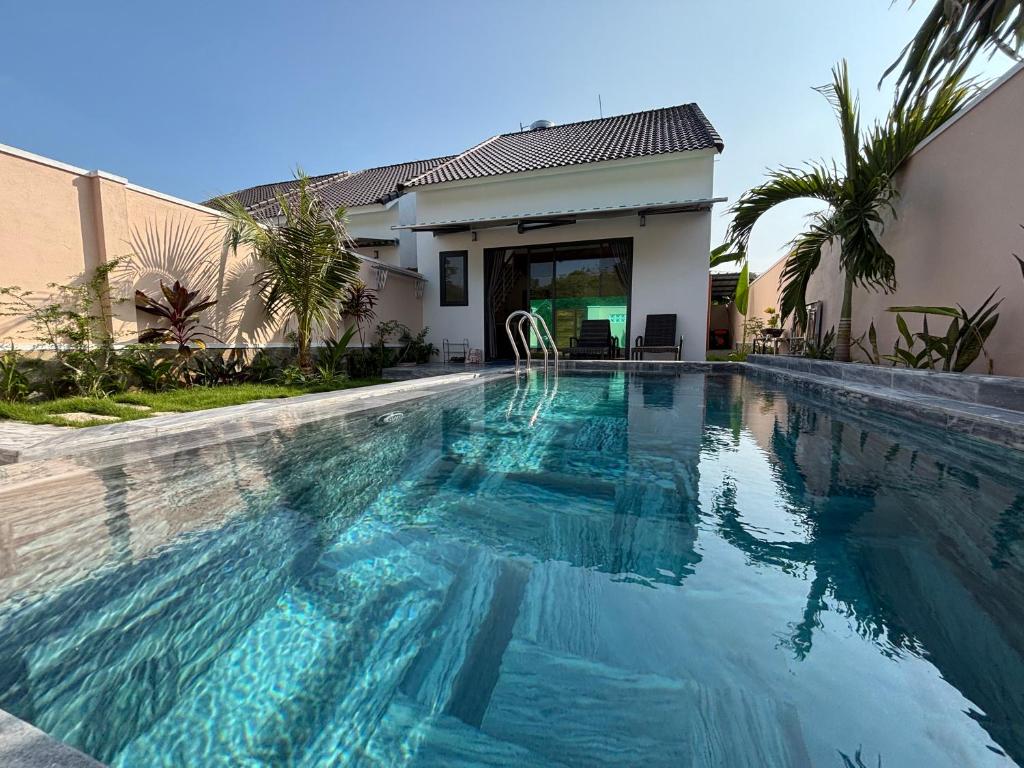 a swimming pool in front of a house at Lisa House Phu Quoc in Phú Quốc