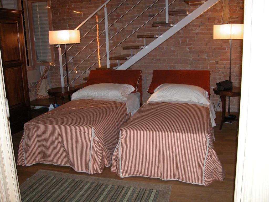 two beds in a room with a staircase at Da Nicola in Montegrotto Terme