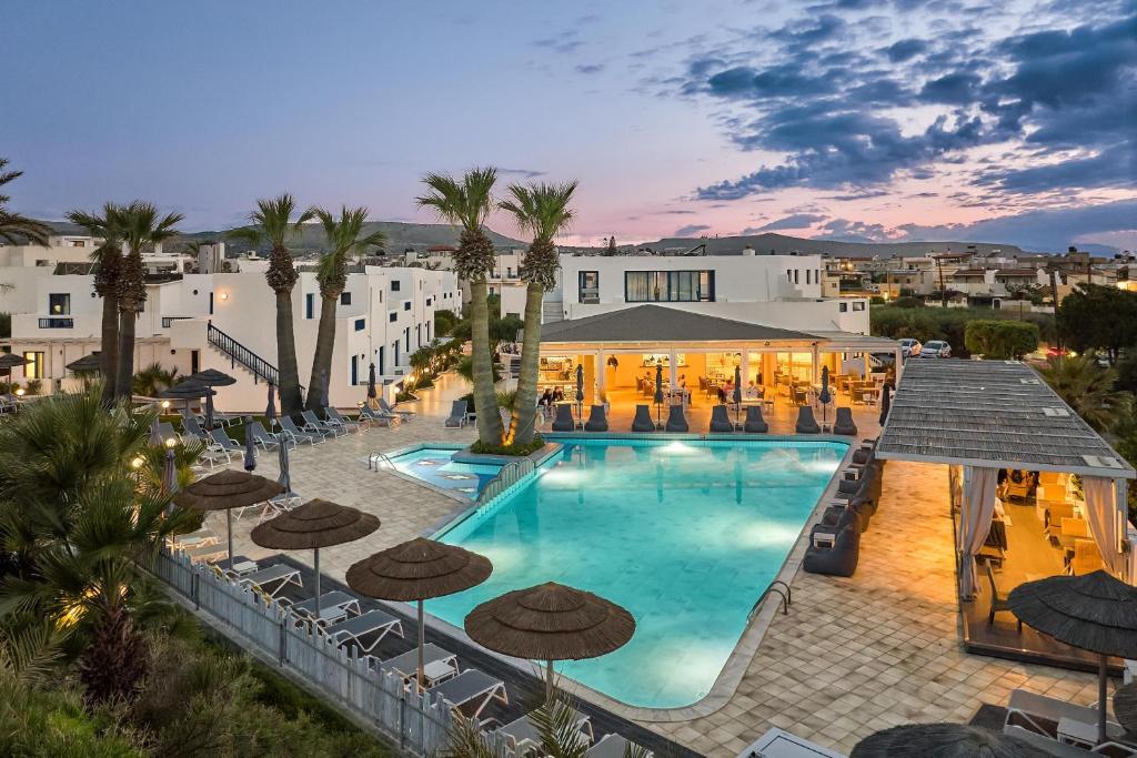 an image of a pool with umbrellas and a hotel at Hara Ilios Village in Gouves