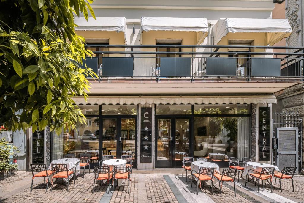 a patio with tables and chairs in front of a building at Hotel Central Giacomini in Salò