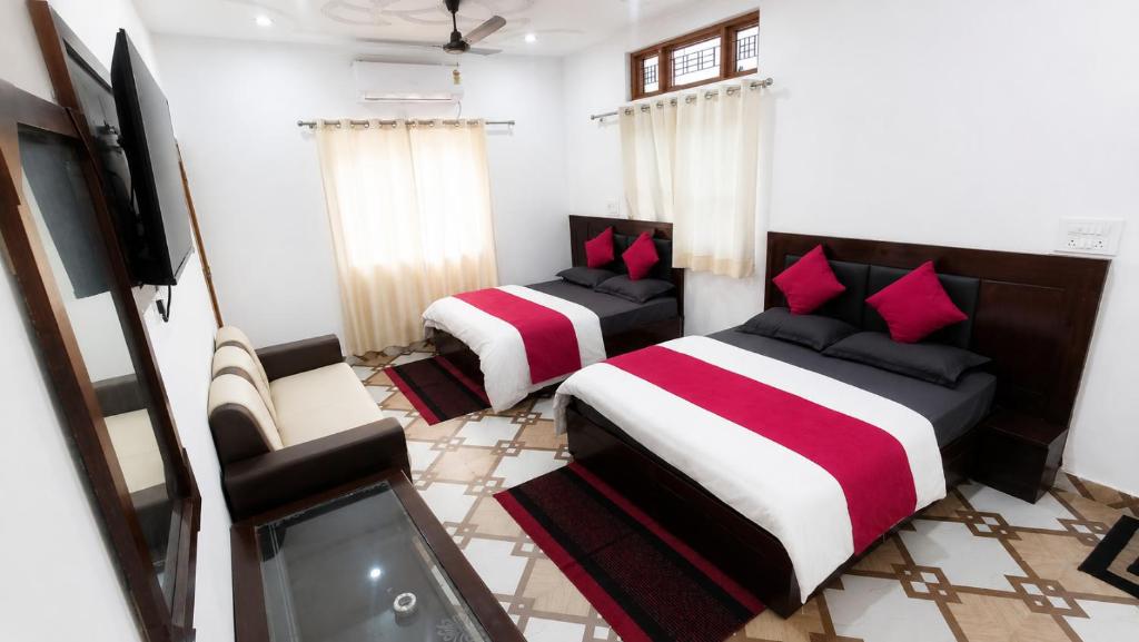 a bedroom with two beds and a tv in it at Bluemoon Stay in Uttarkāshi