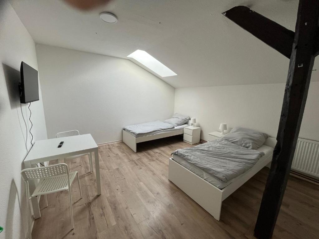 a bedroom with two beds and a desk and a tv at Helles 2 Bettzimmer in Jerrishoe