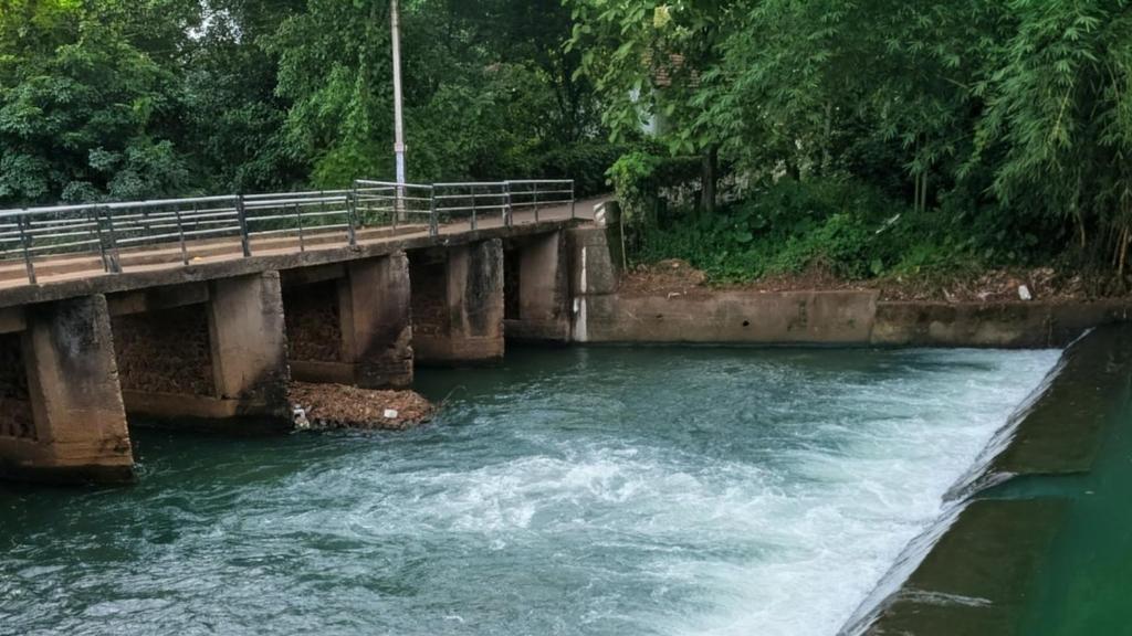 a bridge over a river with water rushing under it at Eons riverdale in Kottayam