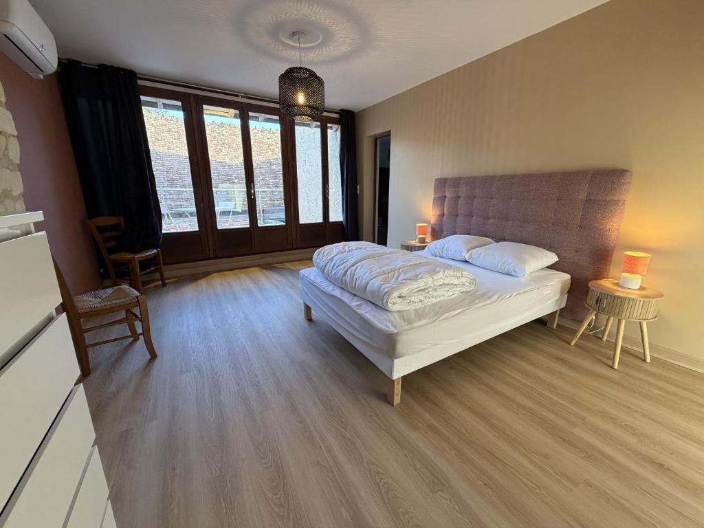 a bedroom with a bed and some windows at Les Remparts T2 et T3 2 Etoiles in La Roche-Posay