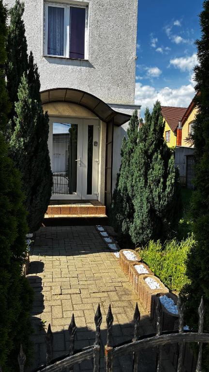a house with a brick patio in front of it at Garden vibe apartament in Luduş
