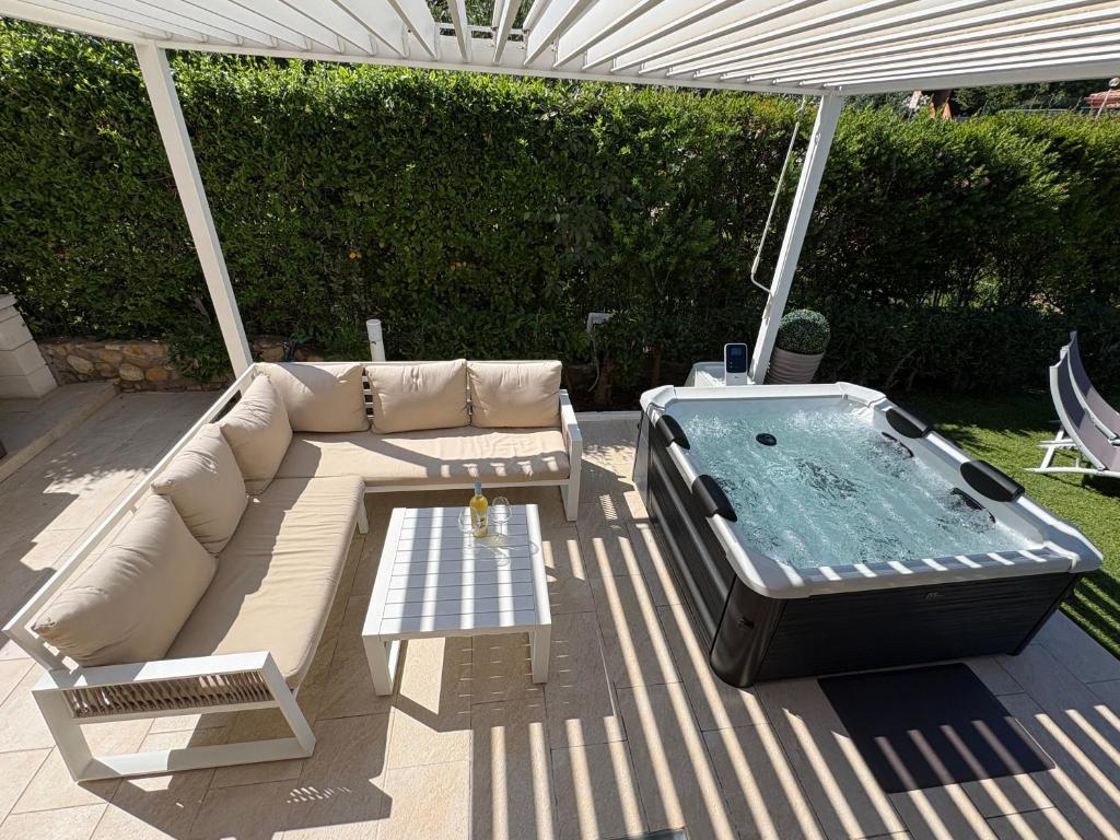 a patio with a couch and a hot tub at Villa Anna in Costa Rei