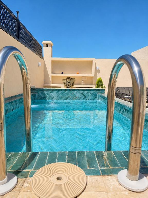 a swimming pool with blue water in a building at Riad Marhaba in Marrakesh