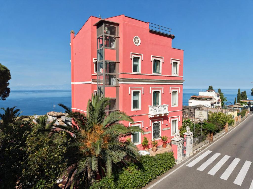 a pink building on the side of a road at Hotel "La Pensione Svizzera" in Taormina