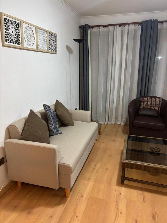 a living room with a white couch and a chair at Casa El Manantial in Vallenar