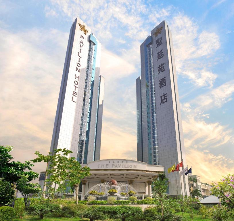 dois edifícios altos numa cidade com árvores na frente em The Pavilion Hotel Shenzhen (Huaqiang NorthBusiness Zone) em Shenzhen