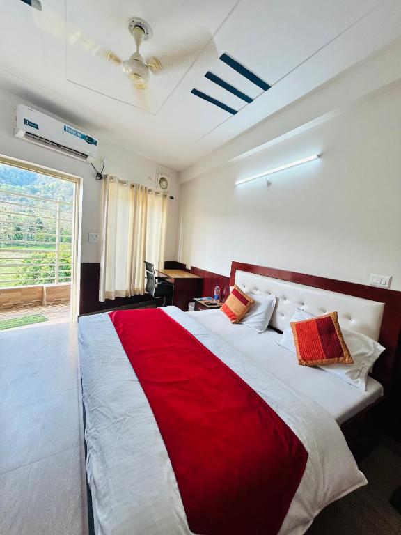 a bedroom with a red and white bed with a window at Hotel Mount View in Haldwāni