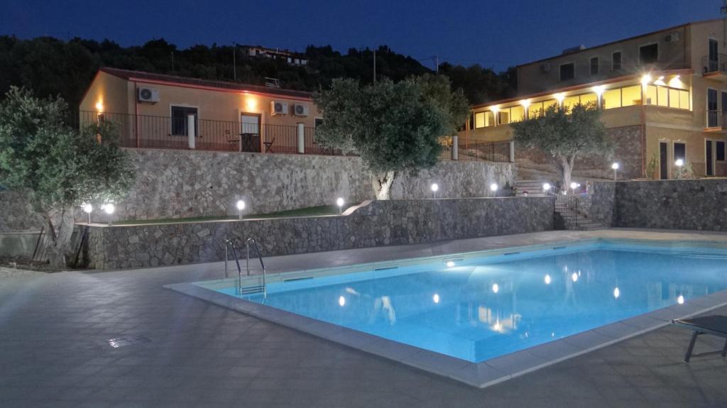 a swimming pool in front of a building at night at La Valle degli Ulivi in Acquedolci