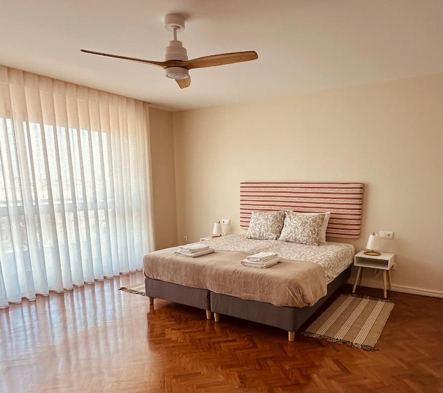 a bedroom with a bed and a ceiling fan at Salty Swell in Porto
