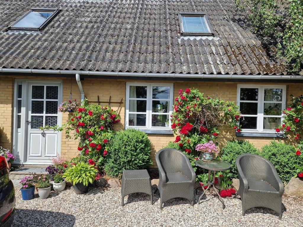 a house with chairs and flowers in front of it at Bakkely in Rønnede