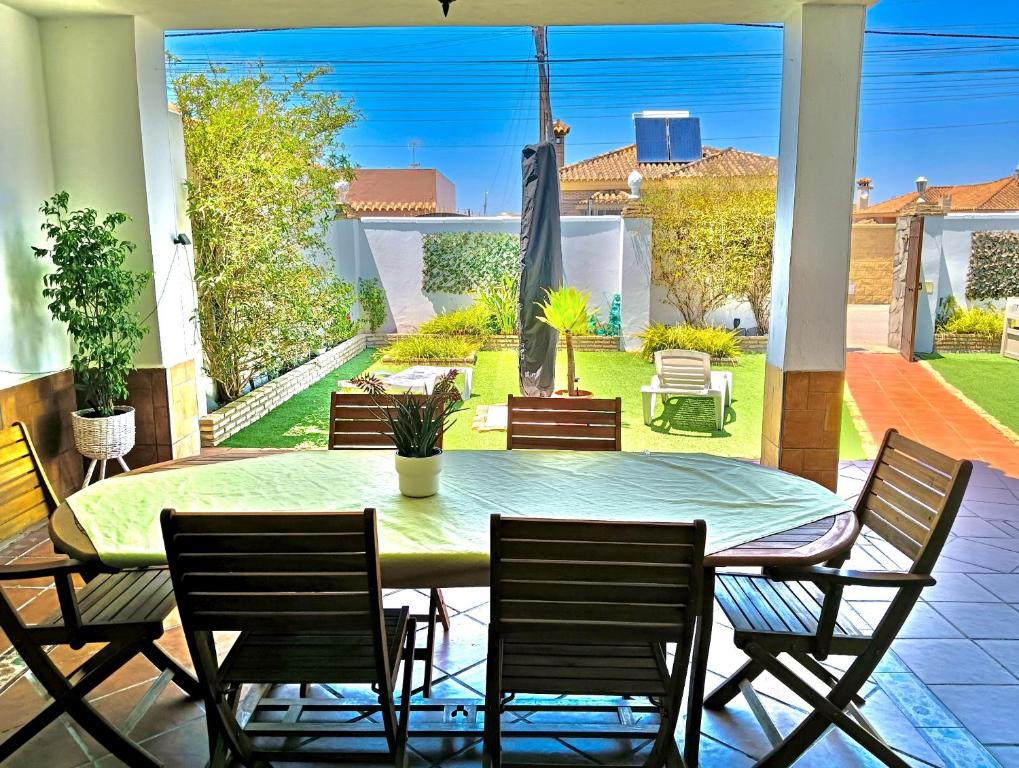 a table and chairs on a patio with a view of a yard at Casa-Chalet Anabel in El Puerto de Santa María