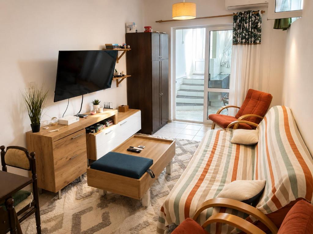 a living room with a couch and a tv at Budva Apartment with Private Parking in Budva