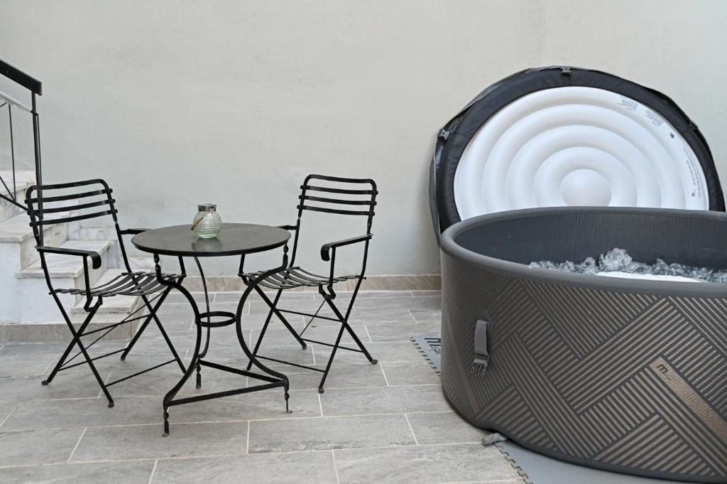 a table and chairs in a room with a hot tub at West of Preveza Luxury Jacuzzi Apartment in Preveza