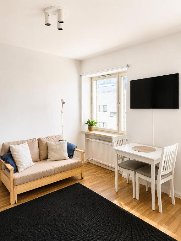 a living room with a couch and a table at Gallen-Kallelankatu 9 in Pori
