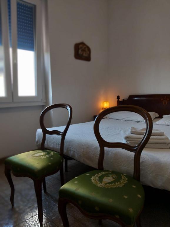 ein Schlafzimmer mit zwei Stühlen, einem Bett und einem Fenster in der Unterkunft Mavipagi 2 in Verona