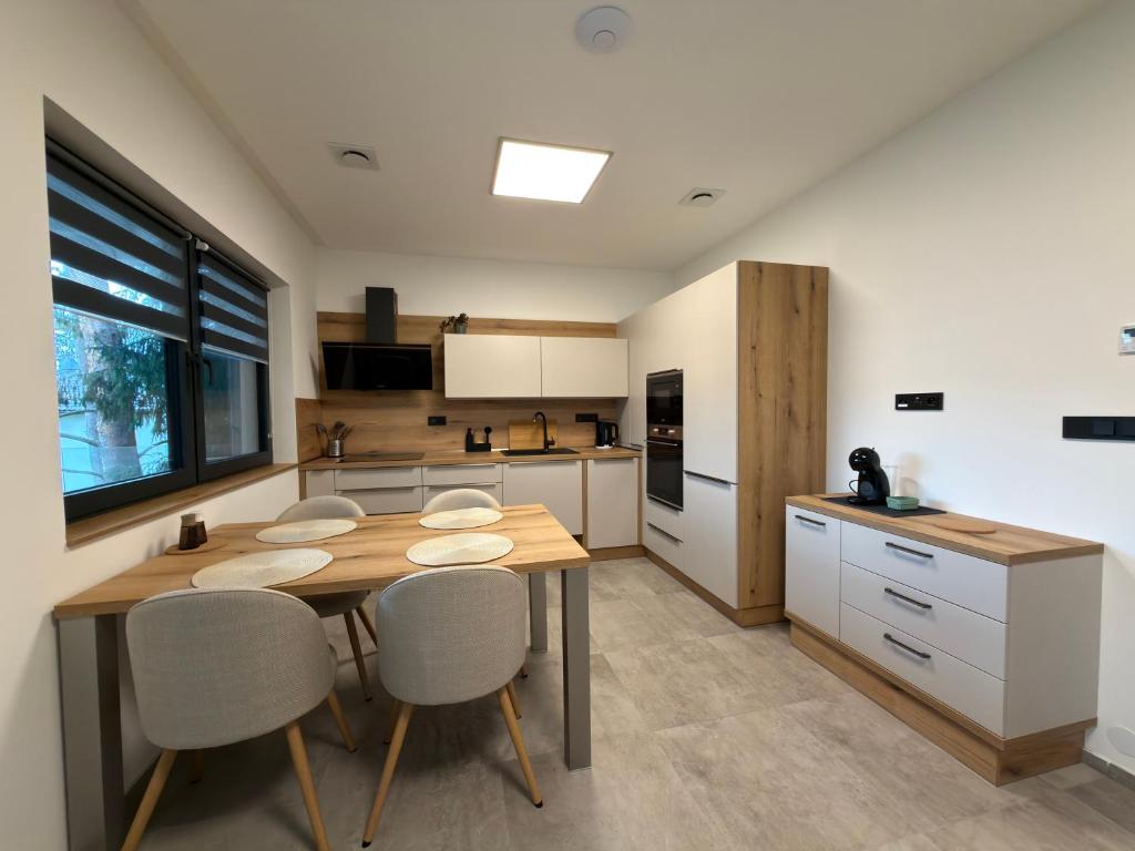 a kitchen with a wooden table and chairs in it at Black Diamond Apartments in Kobylnice
