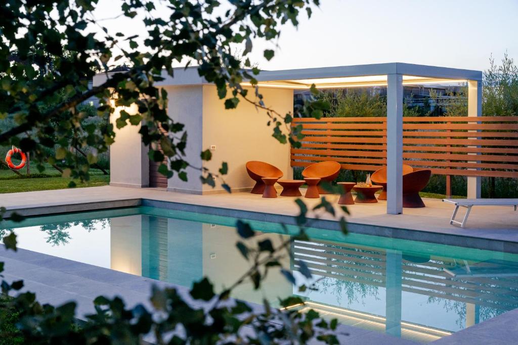 a house with a swimming pool with chairs and a bench at Incanto Toscano in Larciano