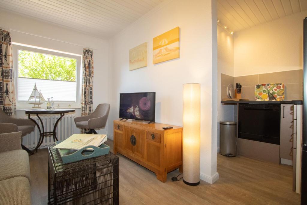 a living room with a couch and a television at Haus Roseneck App.2 in Hörnum