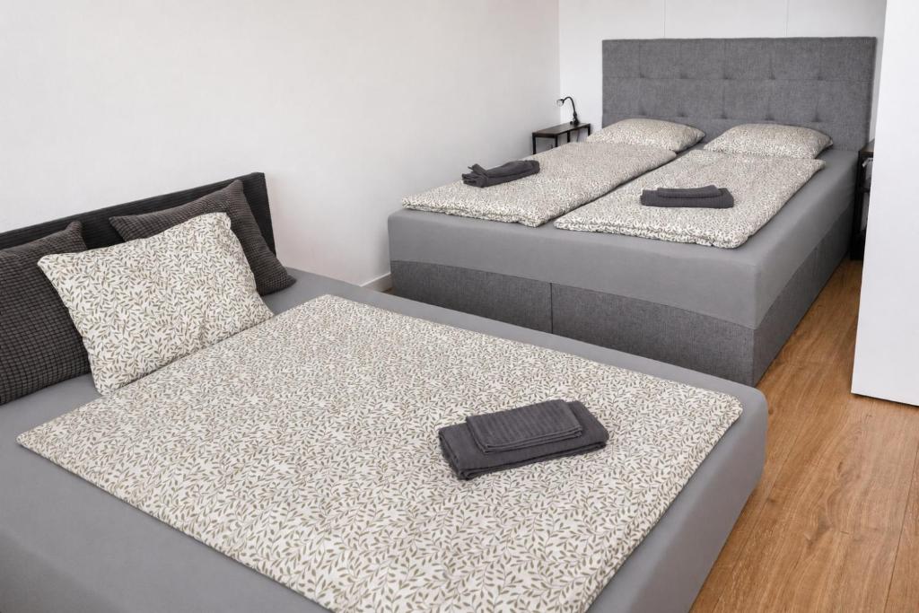 two beds in a room with two bedsskirts at The white Nest Apartment AC & Balcony in Bratislava