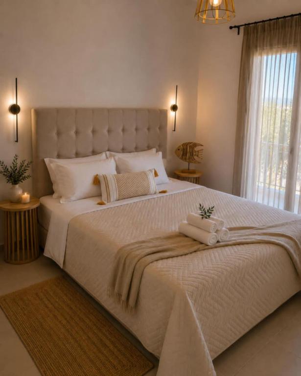 a large white bed with two towels on it at Pagonia Apartments in Arillas