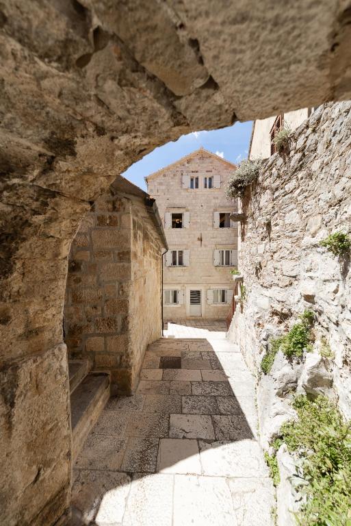 an alley with a stone building in the background at Hotel Corsaro in Omiš
