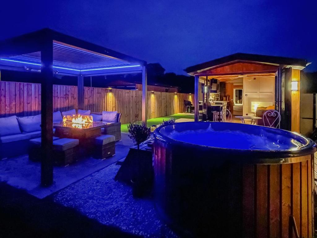 a hot tub in a backyard at night at Sky Lark Lodge - Uk49904 in Appley Bridge