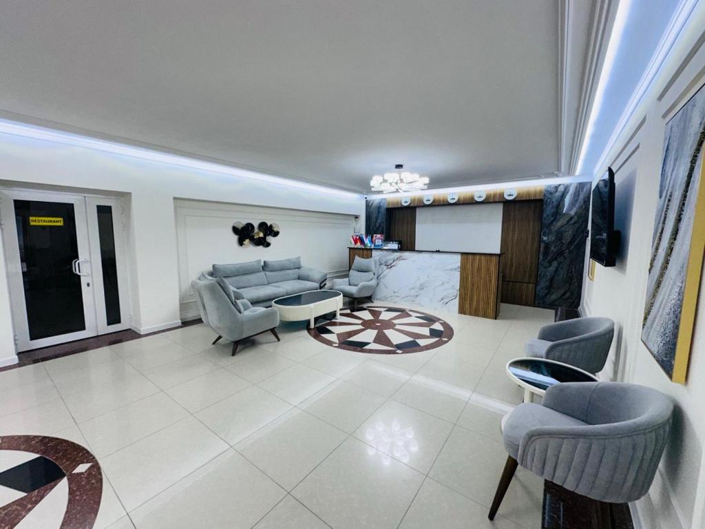 a living room with a couch and chairs and a tv at Grand Silk Road in Samarkand