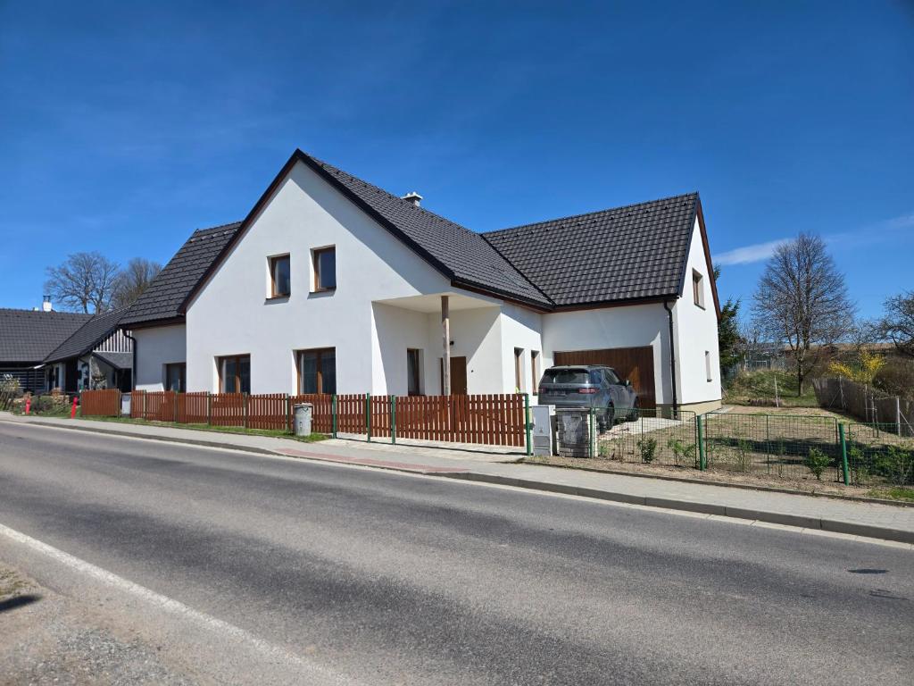 a white house with a fence on the side of the road at Chalupa Svratouch36 in Svratouch