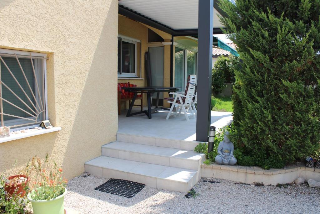 a house with a porch with a table and chairs at Les 1000 Vignes in Frontignan